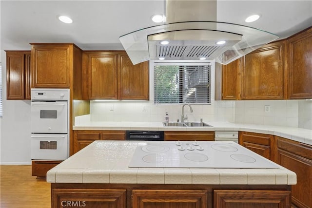 kitchen featuring sink, white appliances, backsplash, a center island, and tile countertops