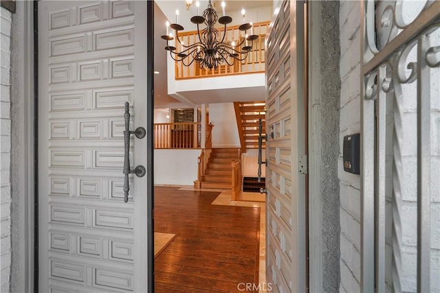 foyer entrance with hardwood / wood-style floors and a notable chandelier