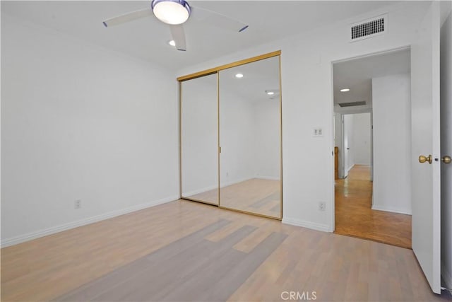 unfurnished bedroom with light hardwood / wood-style flooring, a closet, and ceiling fan