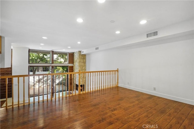 spare room with expansive windows and dark hardwood / wood-style flooring