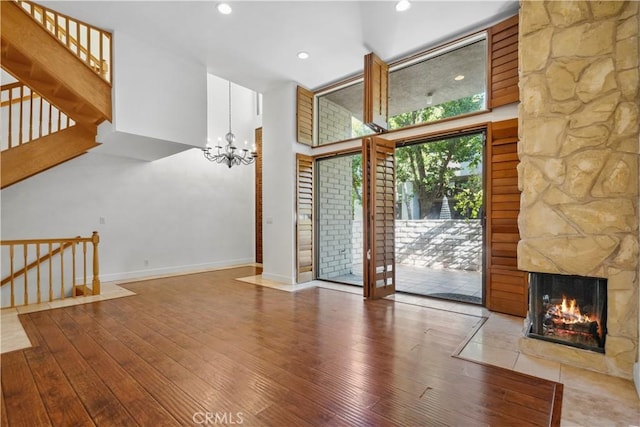 interior space featuring a high ceiling, a multi sided fireplace, an inviting chandelier, and light hardwood / wood-style flooring