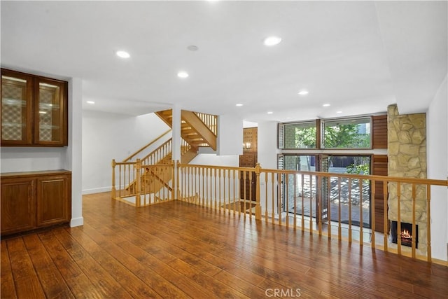 spare room featuring a fireplace, wood-type flooring, and expansive windows