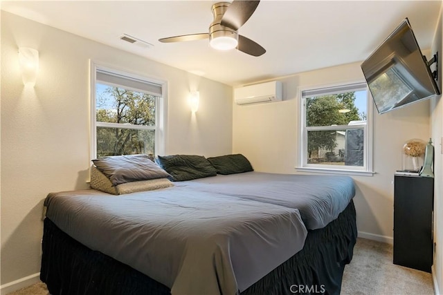 bedroom with a wall mounted air conditioner, light colored carpet, and ceiling fan