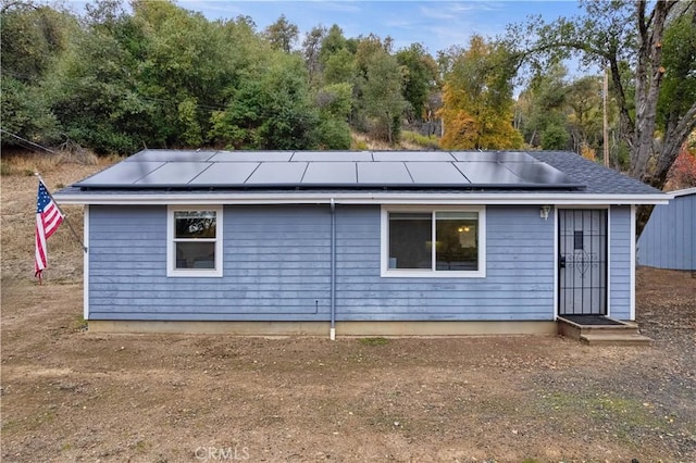 back of house featuring solar panels