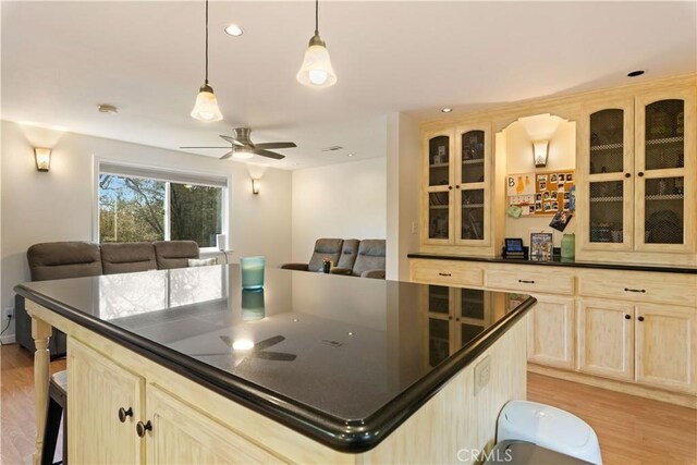 kitchen with pendant lighting, light hardwood / wood-style flooring, a center island, and light brown cabinets