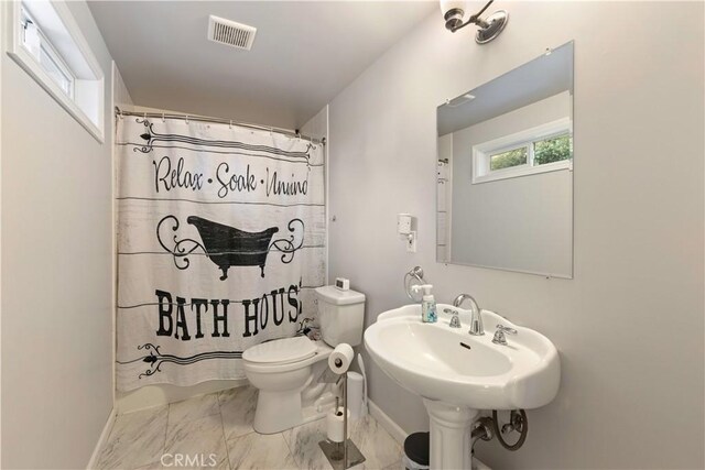 bathroom with a shower with shower curtain, toilet, and sink