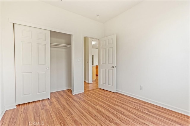 unfurnished bedroom featuring light wood-type flooring and a closet