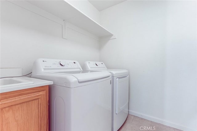 washroom with cabinets, light tile patterned flooring, and washing machine and dryer