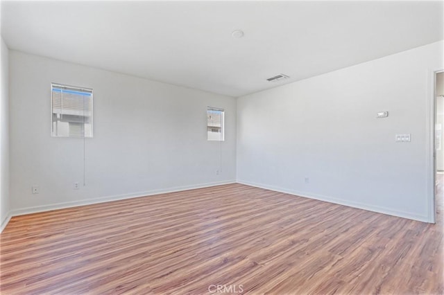 empty room with plenty of natural light and light wood-type flooring