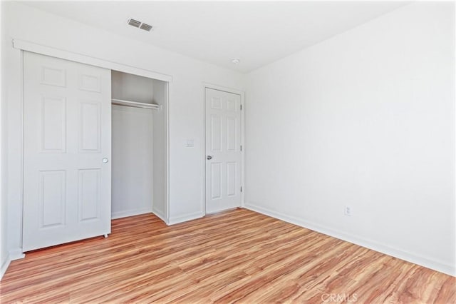 unfurnished bedroom featuring light wood-type flooring and a closet