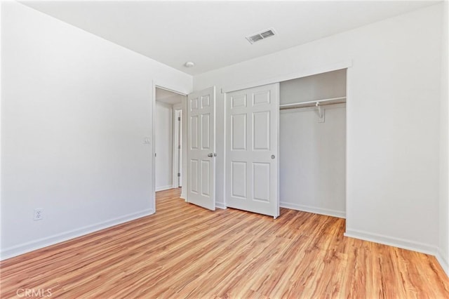 unfurnished bedroom with light hardwood / wood-style floors and a closet