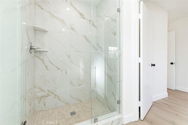 bathroom with an enclosed shower and hardwood / wood-style floors