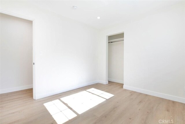 unfurnished bedroom with light hardwood / wood-style flooring and a closet