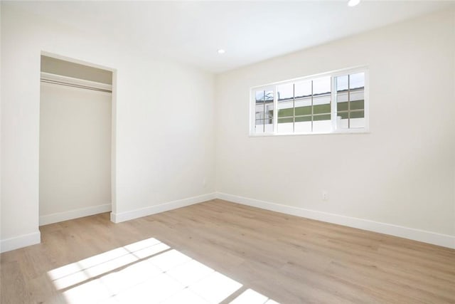 unfurnished bedroom with light hardwood / wood-style floors and a closet