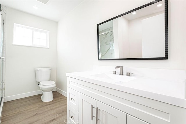 bathroom featuring vanity, wood-type flooring, toilet, and walk in shower