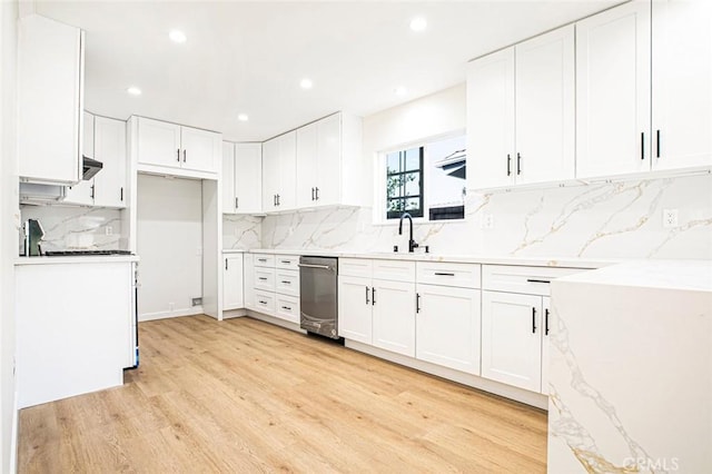 kitchen featuring sink, white cabinetry, tasteful backsplash, light hardwood / wood-style flooring, and light stone countertops