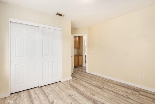 unfurnished bedroom with a closet and light hardwood / wood-style flooring