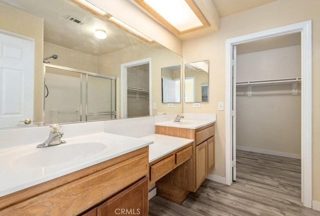 bathroom with vanity, a shower with shower door, and hardwood / wood-style flooring