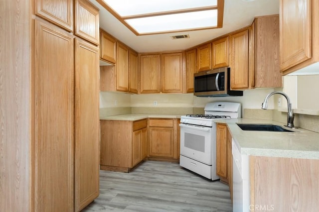 kitchen featuring light hardwood / wood-style floors, white range with gas stovetop, and sink