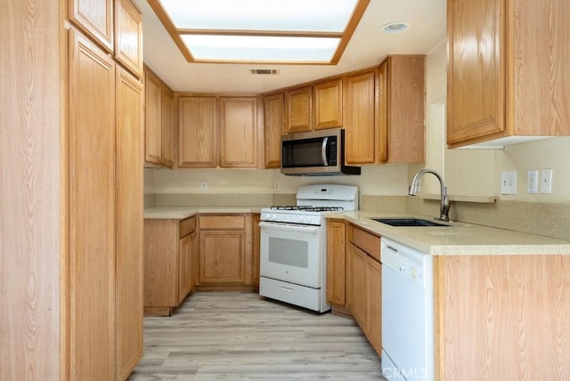 kitchen featuring white appliances, sink, and light hardwood / wood-style flooring