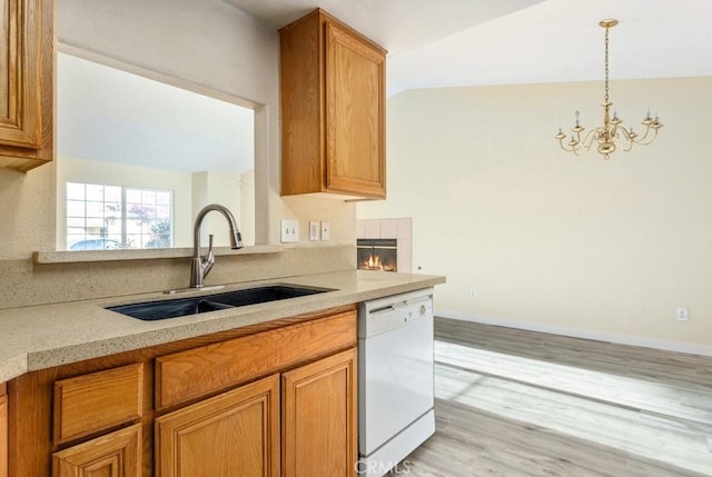 kitchen with sink, a notable chandelier, dishwasher, light hardwood / wood-style floors, and lofted ceiling