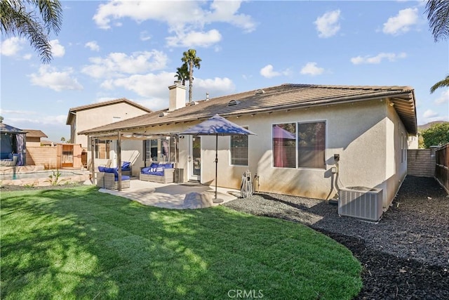 rear view of property with central AC unit, a patio area, and a lawn