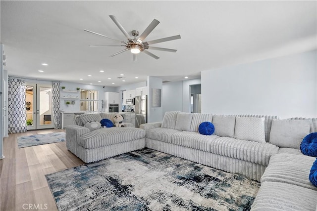 living room with ceiling fan and light wood-type flooring