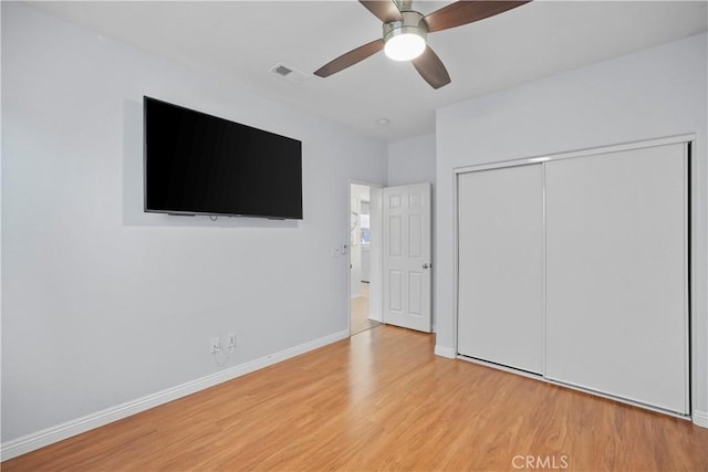 unfurnished bedroom featuring wood-type flooring, a closet, and ceiling fan