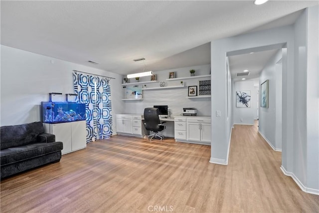 office with light hardwood / wood-style flooring and built in desk