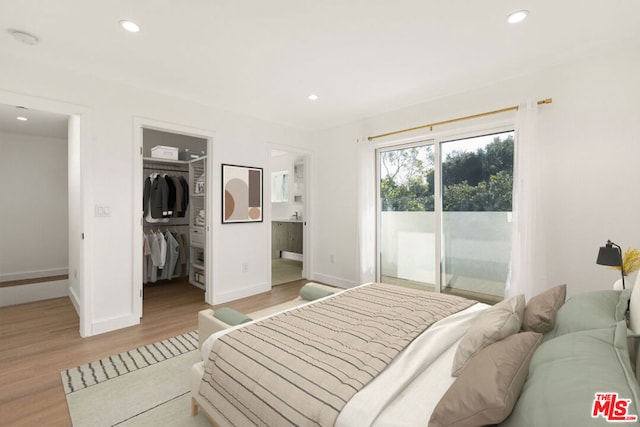 bedroom featuring a walk in closet, ensuite bathroom, access to outside, light hardwood / wood-style floors, and a closet