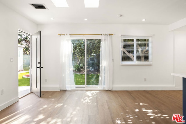 interior space featuring hardwood / wood-style floors, a skylight, and a wealth of natural light