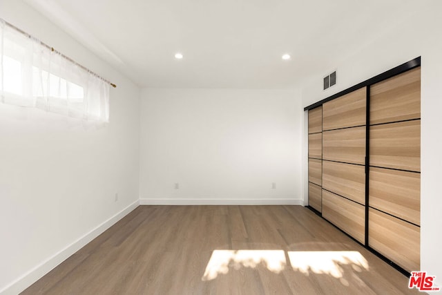 unfurnished bedroom featuring light hardwood / wood-style floors and a closet