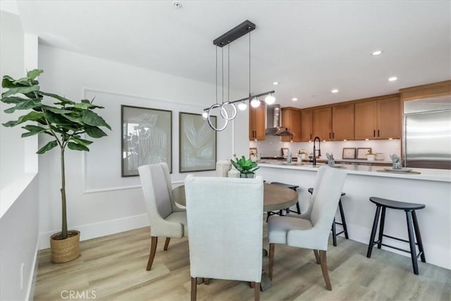 dining space with sink and light hardwood / wood-style flooring