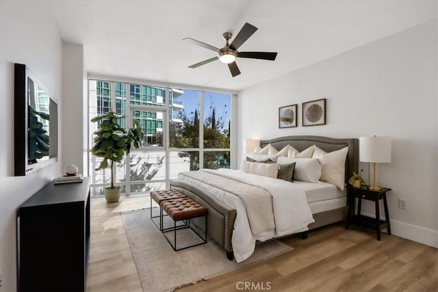 bedroom featuring multiple windows, ceiling fan, and light wood-type flooring