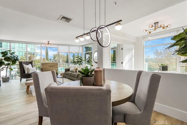 dining area with a chandelier and light hardwood / wood-style floors