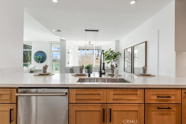 kitchen featuring light stone countertops, dishwasher, sink, kitchen peninsula, and decorative light fixtures