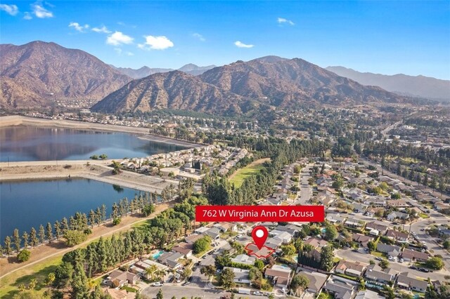 drone / aerial view featuring a water and mountain view