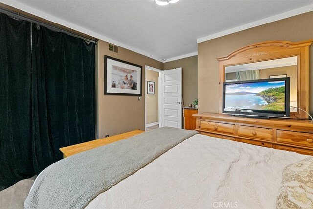 bedroom with a textured ceiling and ornamental molding