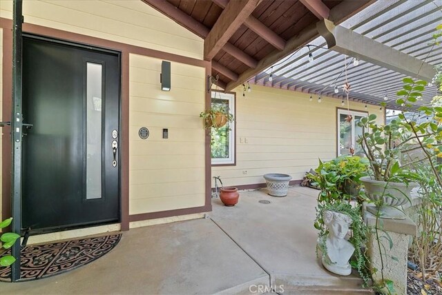 doorway to property with a pergola and a patio area