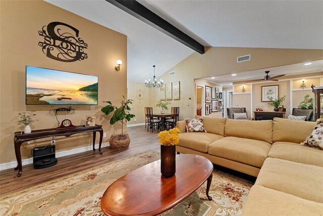 living room featuring lofted ceiling with beams, ceiling fan with notable chandelier, and hardwood / wood-style flooring