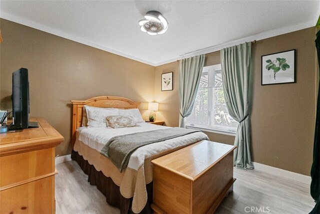 bedroom featuring wood-type flooring and crown molding