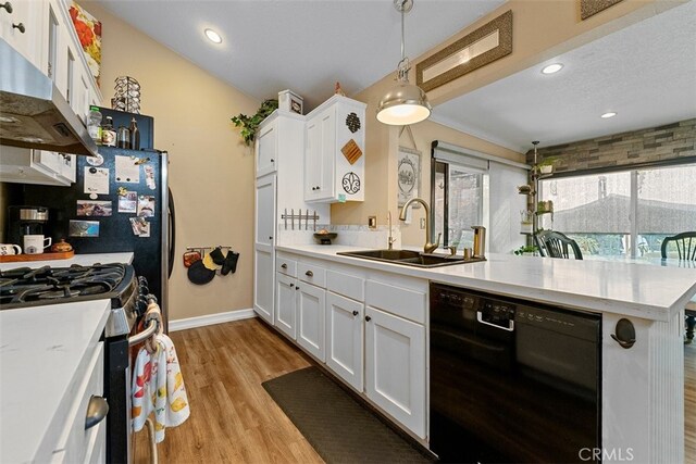 kitchen with sink, range hood, decorative light fixtures, white cabinets, and black appliances