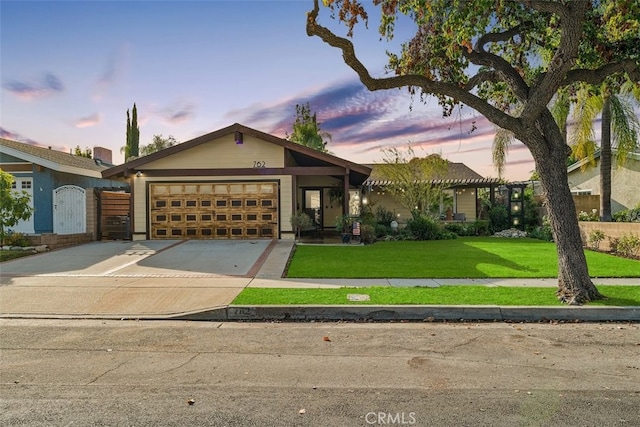 view of front of home with a garage and a yard