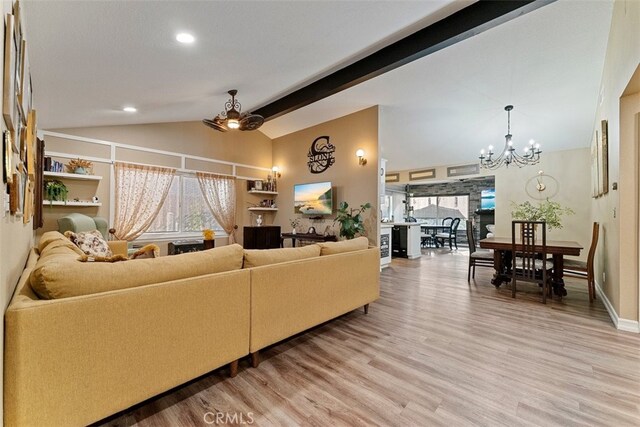 living room with ceiling fan with notable chandelier, wood-type flooring, and vaulted ceiling with beams