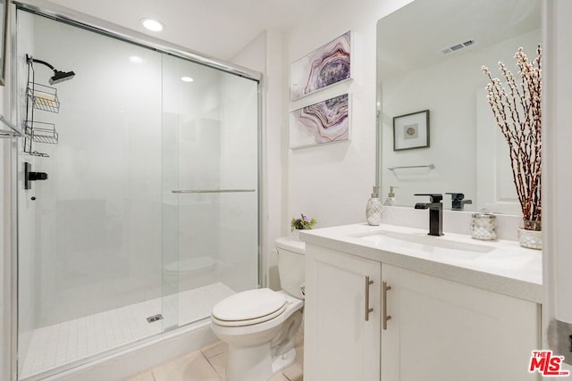 bathroom featuring tile patterned flooring, vanity, toilet, and walk in shower