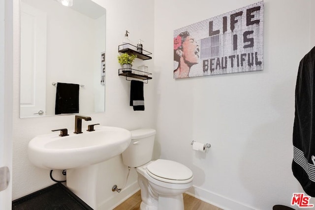 bathroom featuring hardwood / wood-style floors and toilet