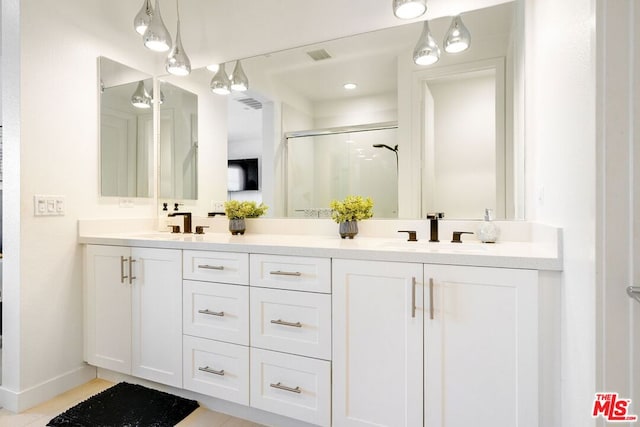 bathroom featuring a shower with door, vanity, and tile patterned flooring