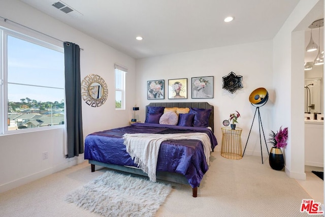 bedroom featuring ensuite bath and carpet floors