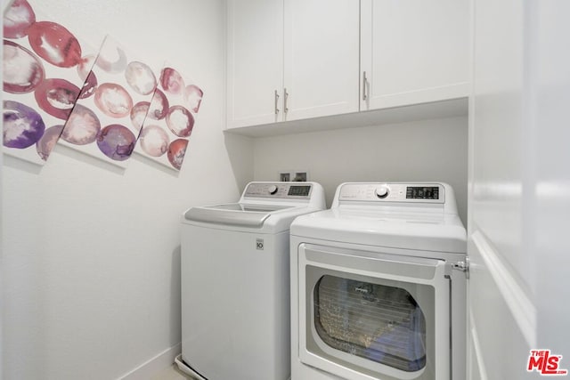 laundry area with washer and dryer and cabinets