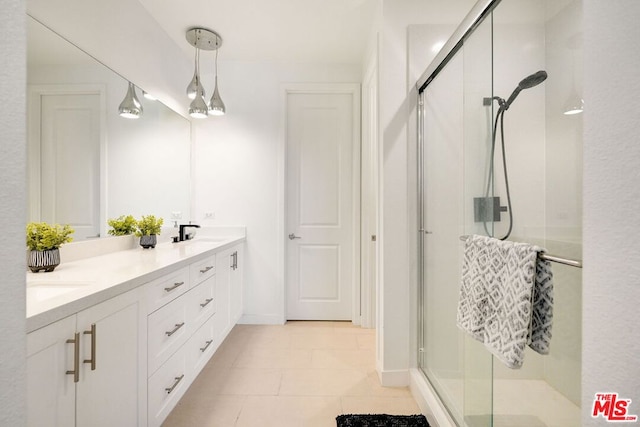 bathroom featuring tile patterned flooring, vanity, and walk in shower